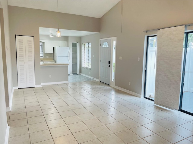 foyer featuring light tile patterned flooring and a towering ceiling