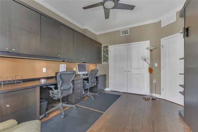 office area with crown molding, ceiling fan, dark hardwood / wood-style flooring, and built in desk