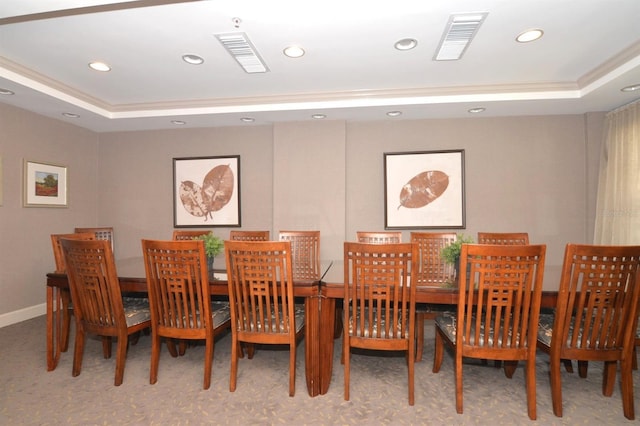 carpeted dining area with a raised ceiling