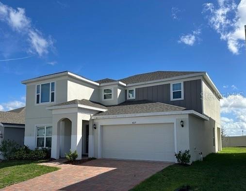 view of front of property with a garage and a front lawn