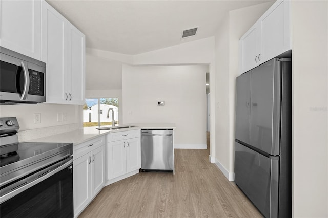 kitchen featuring sink, light wood-type flooring, white cabinets, and appliances with stainless steel finishes