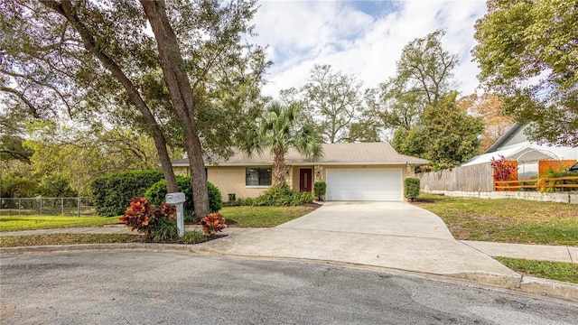 single story home with stucco siding, an attached garage, driveway, and fence