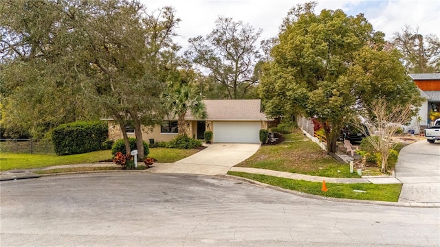 view of front facade featuring a garage, concrete driveway, a front lawn, and fence