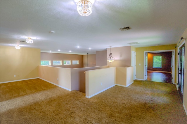 unfurnished room with plenty of natural light, carpet, and a textured ceiling