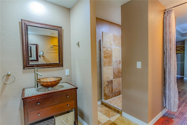 bathroom featuring vanity and tiled shower