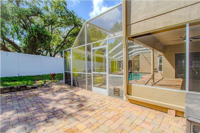 unfurnished sunroom featuring ceiling fan