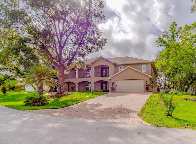 mediterranean / spanish home featuring a garage, a balcony, and a front lawn