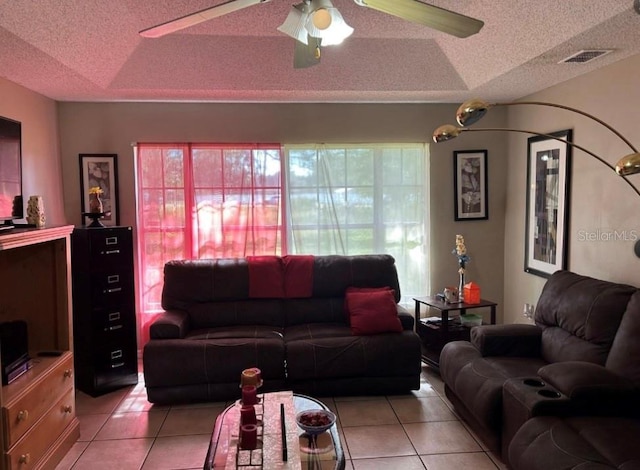 living room featuring light tile patterned flooring, ceiling fan, and a textured ceiling