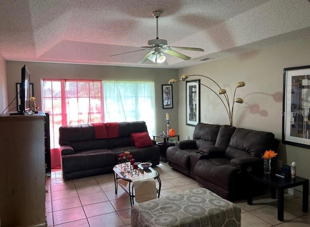 living room with light tile patterned flooring, a wealth of natural light, ceiling fan, and a textured ceiling