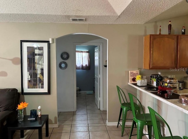 kitchen featuring light tile patterned flooring and a textured ceiling