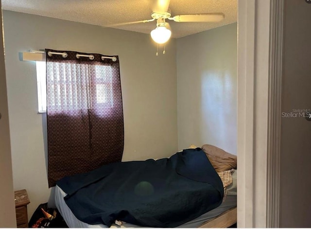 bedroom featuring ceiling fan and a textured ceiling