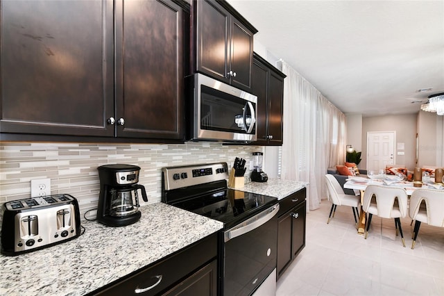3373 Lilac Way, Davenport, FL 33897 - kitchen featuring dark brown cabinetry, decorative backsplash, and stainless steel appliances