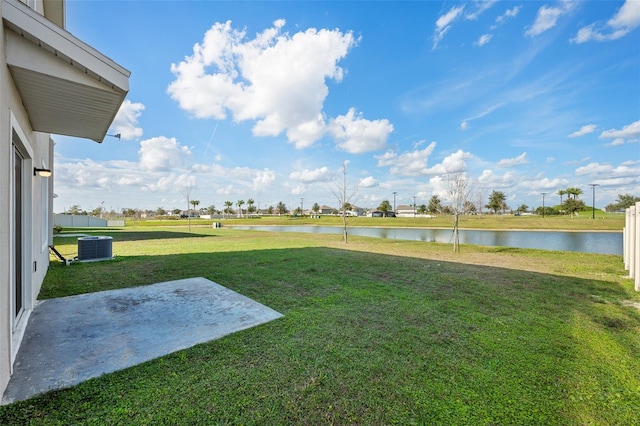 view of yard featuring a water view, a patio area, and central AC unit