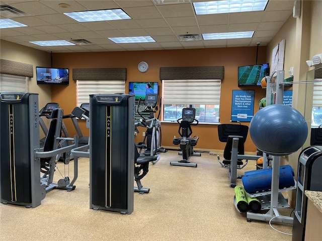 gym featuring a paneled ceiling, baseboards, and visible vents