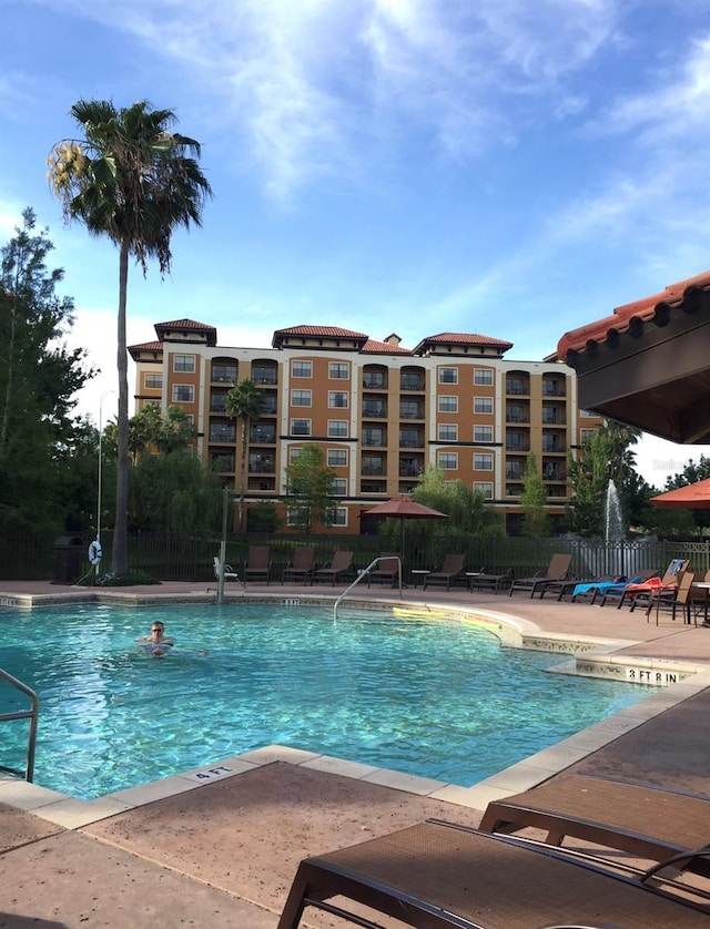 community pool featuring a patio area and fence