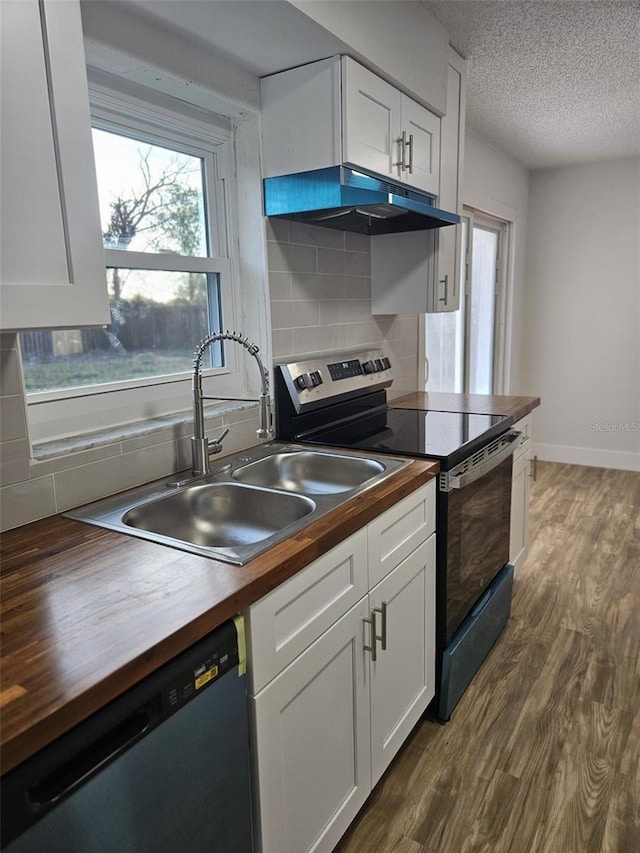 kitchen featuring appliances with stainless steel finishes, wood counters, white cabinetry, dark hardwood / wood-style flooring, and plenty of natural light