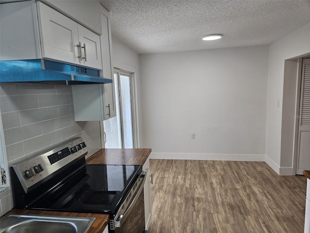 kitchen featuring hardwood / wood-style flooring, white cabinetry, tasteful backsplash, a textured ceiling, and stainless steel electric stove