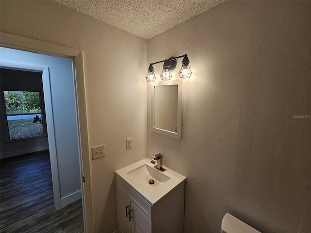 bathroom with vanity, hardwood / wood-style floors, and a textured ceiling