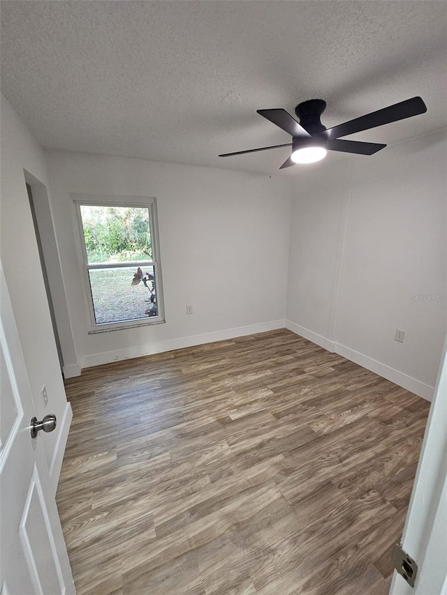 empty room featuring hardwood / wood-style floors and a textured ceiling