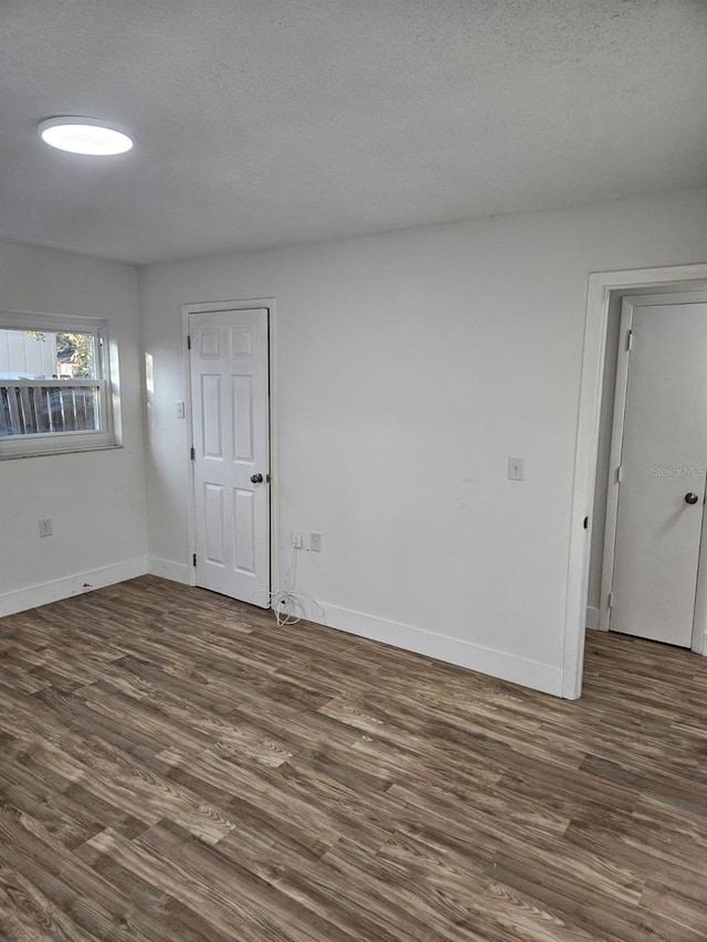 unfurnished room with dark hardwood / wood-style floors and a textured ceiling