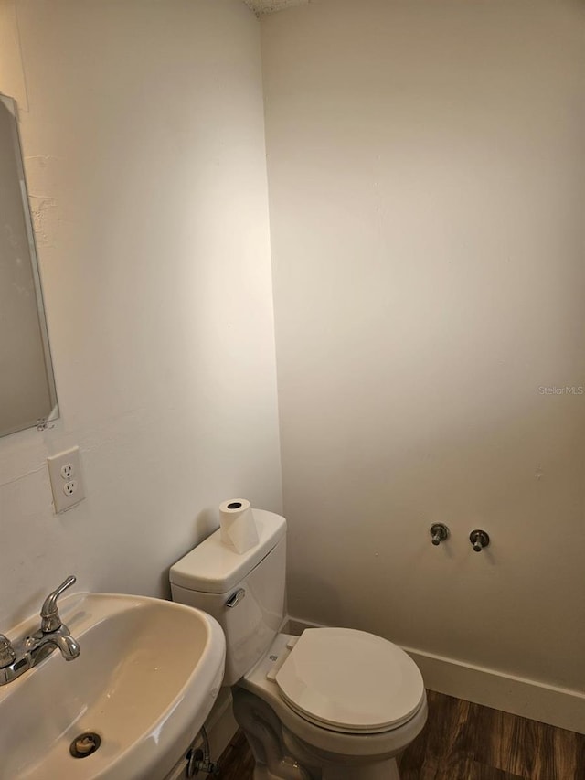 bathroom with sink, hardwood / wood-style floors, and toilet