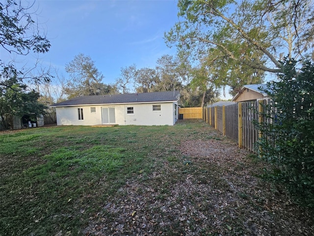 rear view of house featuring a yard