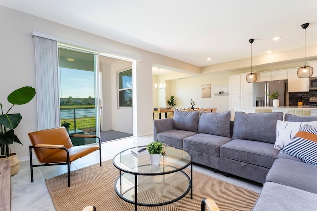 tiled living room featuring a notable chandelier and a water view