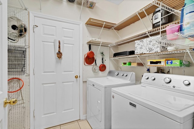 clothes washing area featuring washing machine and clothes dryer and light tile patterned floors