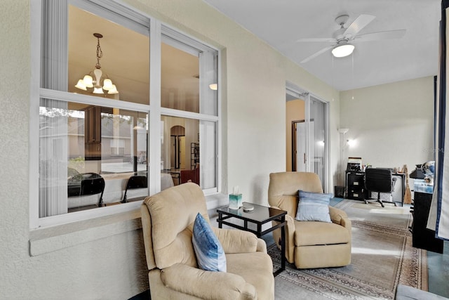 living room featuring ceiling fan with notable chandelier