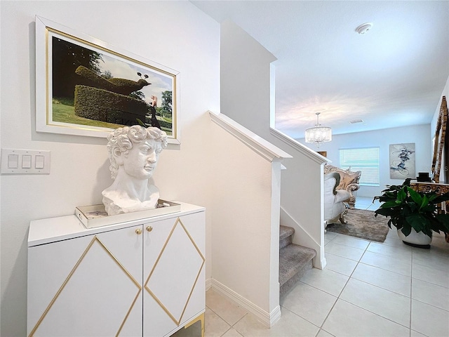 stairs with tile patterned flooring, a chandelier, and baseboards