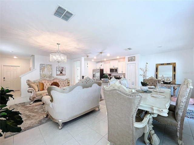 dining area featuring light tile patterned floors, visible vents, and an inviting chandelier