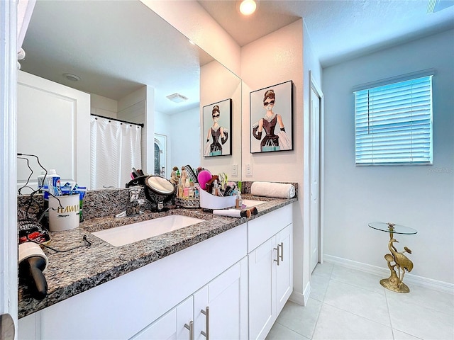 full bathroom featuring double vanity, visible vents, a sink, and tile patterned floors