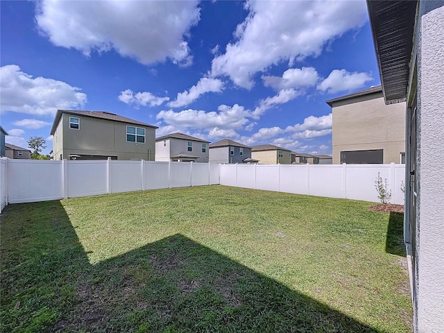 view of yard with a fenced backyard and a residential view