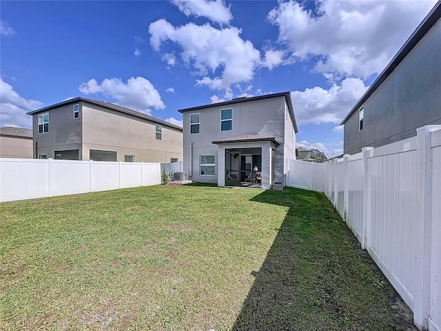 rear view of property with central AC unit, a lawn, a fenced backyard, and stucco siding