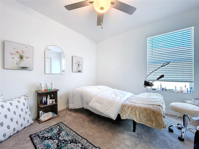 carpeted bedroom with ceiling fan and baseboards