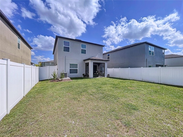 rear view of property with central AC unit, a fenced backyard, a sunroom, a yard, and stucco siding