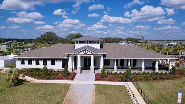 view of front of property featuring a front yard, roof with shingles, and a residential view