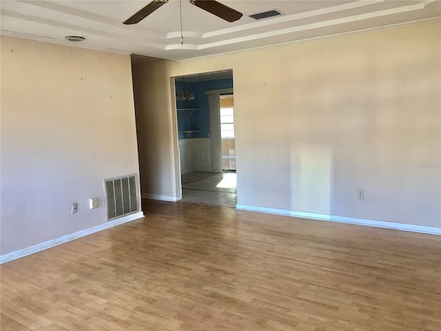 unfurnished room featuring crown molding, hardwood / wood-style floors, ceiling fan, and a tray ceiling