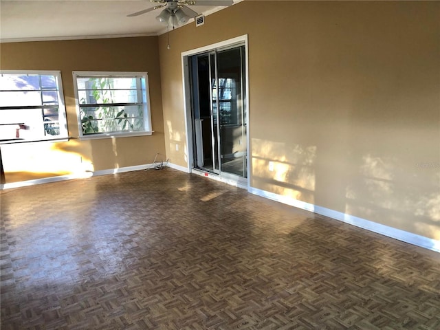 empty room with ceiling fan, ornamental molding, and dark parquet floors