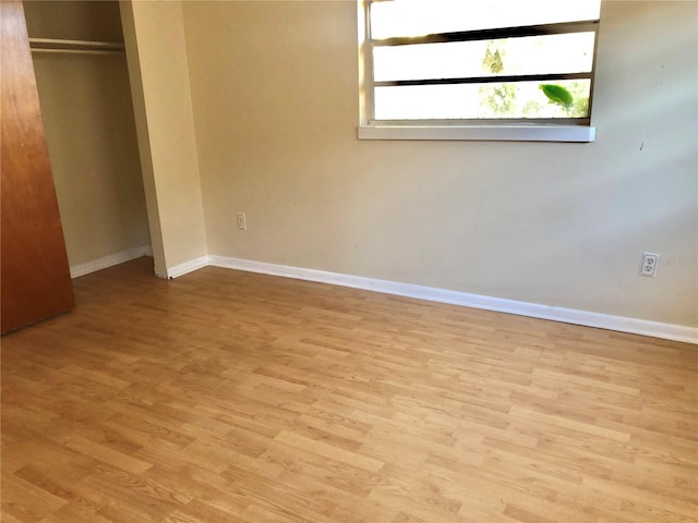 unfurnished bedroom featuring light hardwood / wood-style floors and a closet