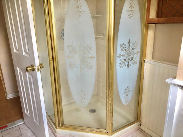 bathroom with a shower with door and tile patterned floors