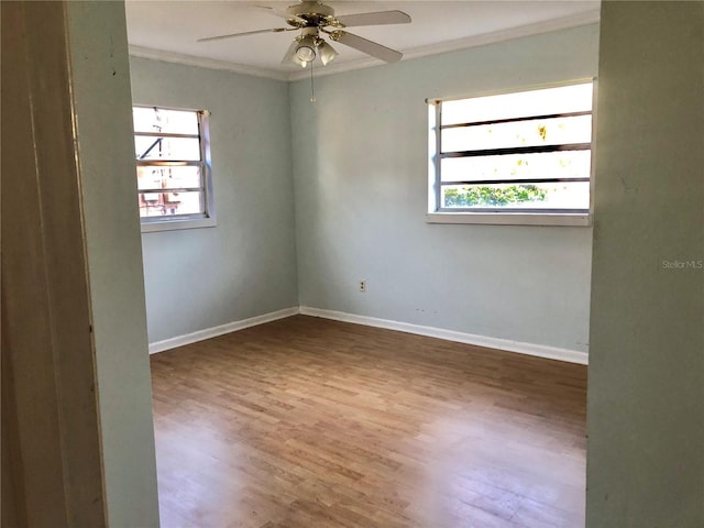 empty room with hardwood / wood-style flooring, ornamental molding, a healthy amount of sunlight, and ceiling fan