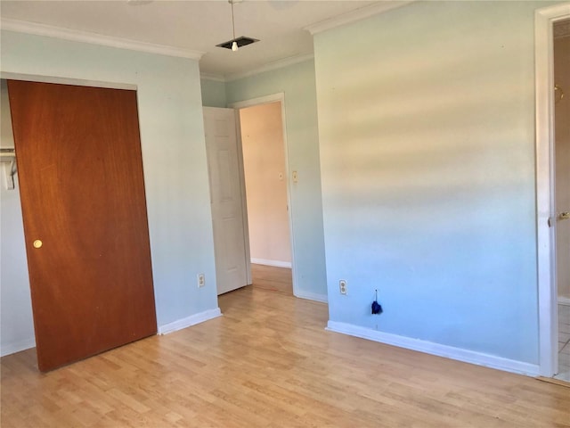 unfurnished bedroom featuring crown molding, light wood-type flooring, and a closet