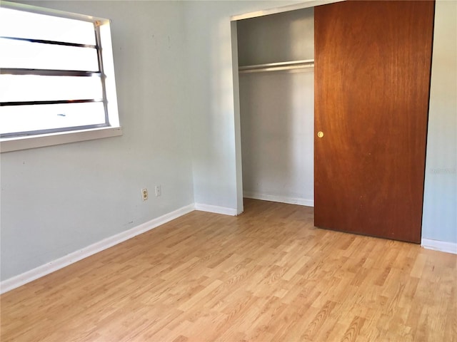 unfurnished bedroom with light hardwood / wood-style floors and a closet