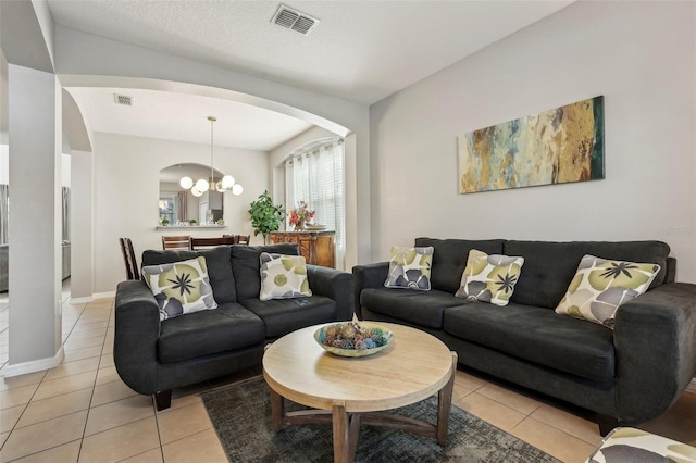 tiled living room featuring a notable chandelier