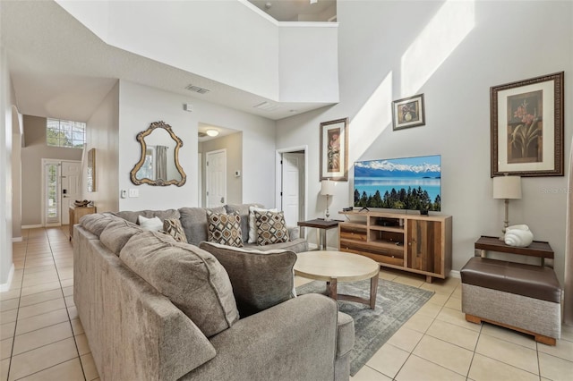 living room featuring a towering ceiling and light tile patterned flooring