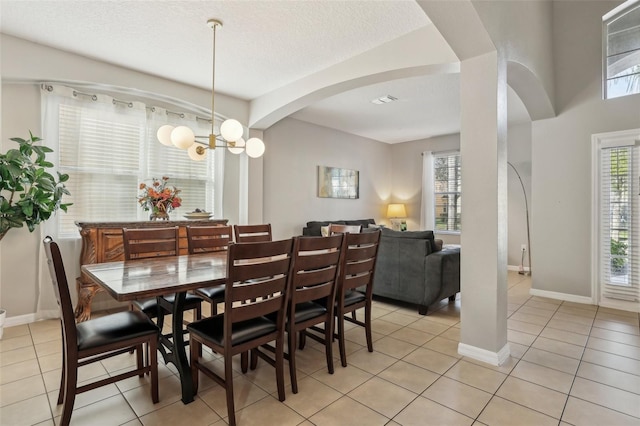 tiled dining space featuring an inviting chandelier and a textured ceiling