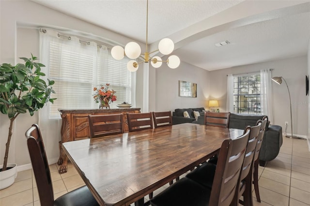 tiled dining space featuring a textured ceiling