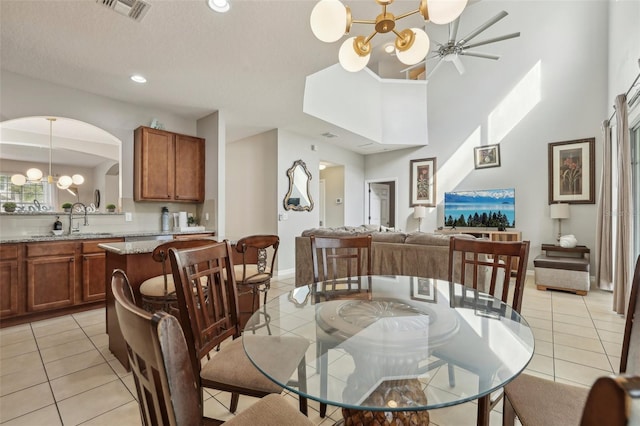 dining room featuring sink, a textured ceiling, an inviting chandelier, and light tile patterned floors