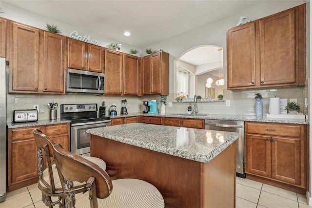 kitchen featuring a center island, decorative backsplash, stainless steel appliances, and sink